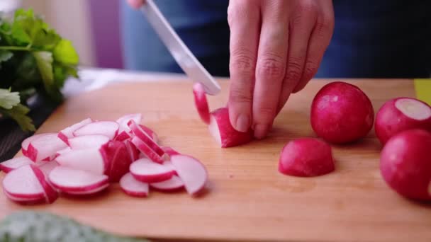Ahşap kesim tahtasında turp dilimleyen kadının yakınlaştırılması - yemek malzemesi hazırlama — Stok video