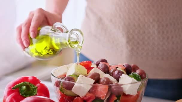 Concepto de la serie de preparación de ensalada griega - mujer vertiendo aceite de oliva en un tazón con verduras picadas — Vídeo de stock