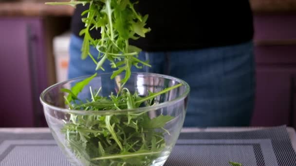 Estilo de vida saudável - Mulher derramando arugula em tigela de vidro — Vídeo de Stock