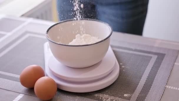 Dough preparation - Woman Cook pours flour to ceramic bowl on kitchen scales — ストック動画