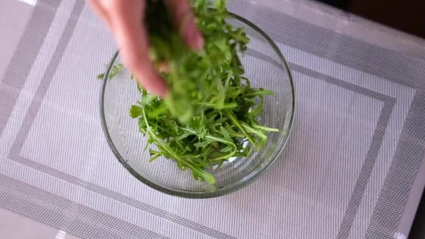 Estilo de vida saludable - Mujer vertiendo rúcula en un recipiente de vidrio — Vídeos de Stock