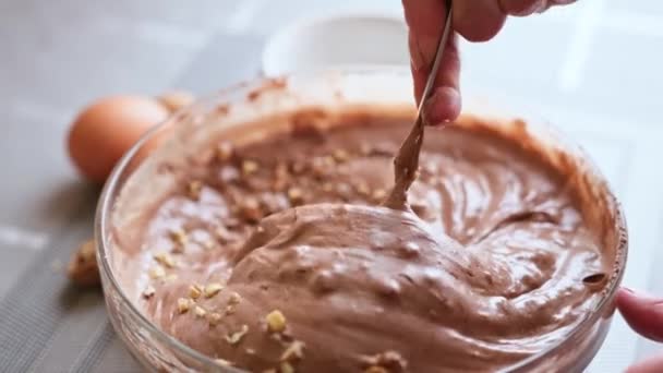 Cevizli çikolatalı kek yapmak - cam kasede çiğ hamura ceviz eklemek — Stok video