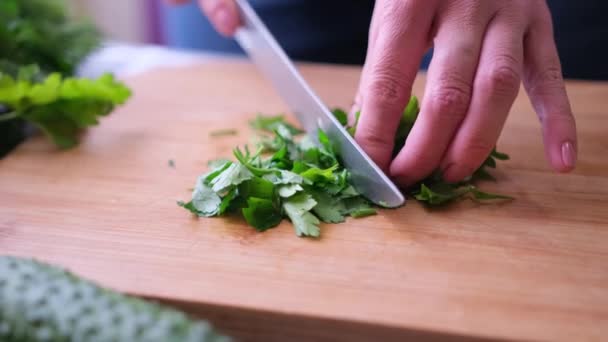 Close-up van de vrouw snijden peterselie op houten snijplank - voorbereiding ingrediënt voor maaltijd — Stockvideo