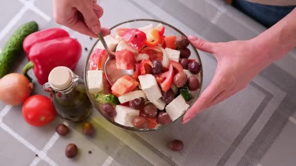 希腊色拉烹调系列概念-妇女在玻璃碗中混合切碎的蔬菜 — 图库视频影像