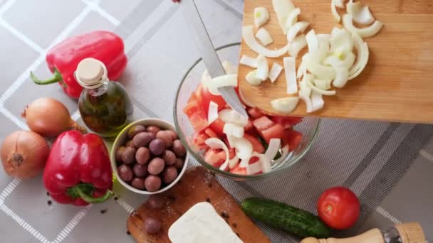 Grekisk sallad förberedelse serie koncept - kvinna hälla skivade lök i en skål — Stockvideo