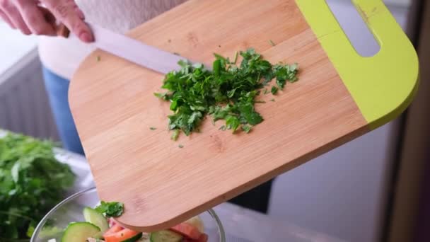 Closeup of woman slicing parsley on wooden cutting board - preparing ingredient for meal — Wideo stockowe