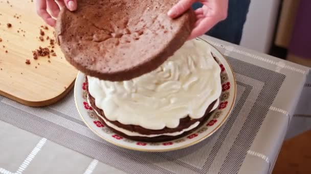 Culinario, concepto de cocción - Mujer pastelera está poniendo la torta de esponja superior en la crema haciendo pastel — Vídeos de Stock