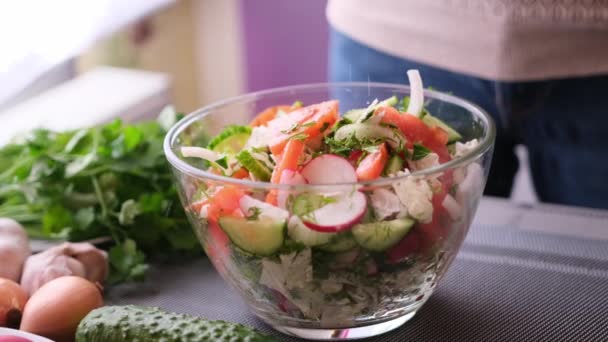 Woman adding salt and spices into mixed salad of vegetables - tomatoes, cucumbers, onion, parsley — Vídeos de Stock