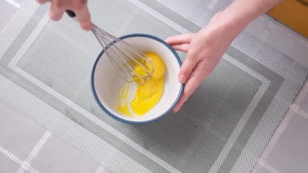 Apple pie cake preparation series - woman beat eggs in a glass bowl with a whisk — Stok Video