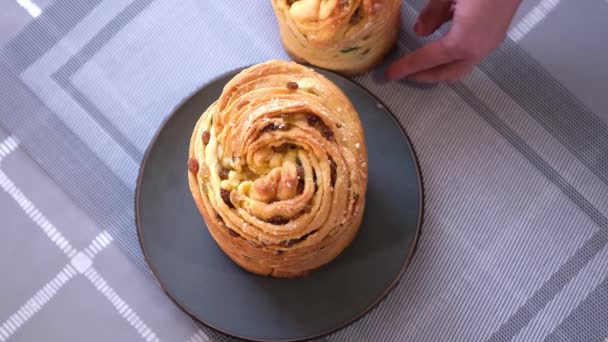 Young woman puts fresh baked easter cake cruffin on kitchen table — Wideo stockowe
