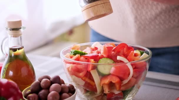 Greek salad preparation series concept - woman peppers chopped vegetables in a glass bowl — Stockvideo