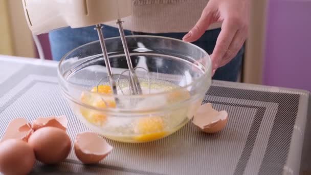 식탁 위에 놓인 그릇에 케이크를 섞어 만든 반죽을 여자 손으로 저으는 모습 — 비디오