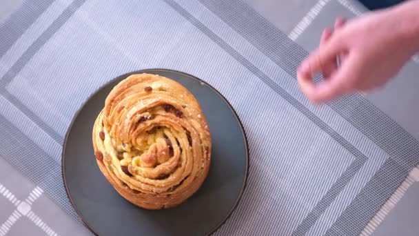 Young woman puts fresh baked easter cake cruffin on kitchen table — Vídeo de stock