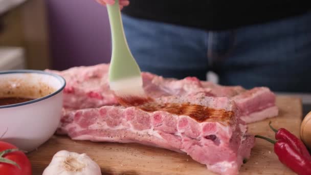 Ribs get glazed with brush with sweet barbeque sauce in slow motion closeup — Stok video