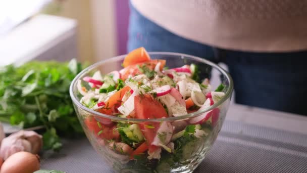 Donna che aggiunge il sale e le spezie in insalata mista di verdure - pomodori, cetrioli, cipolla, prezzemolo — Video Stock