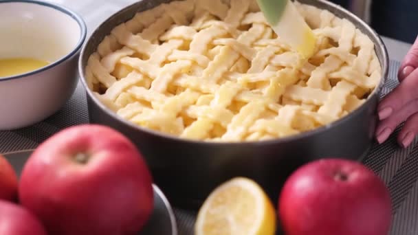 Apple pie cake preparation series - Woman brushing pie with beaten eggs before to put them in oven — Wideo stockowe