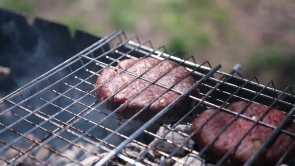 Beef burgers cutlets are roasting on the charcoal barbecue grill — Stockvideo
