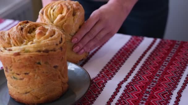 Young woman puts fresh baked easter cake cruffin on kitchen table — Stock video