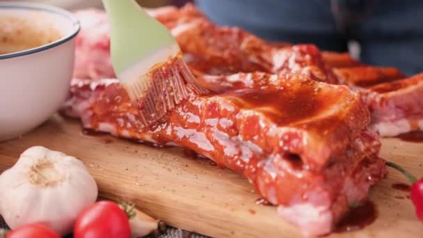Ribs get glazed with brush with sweet barbeque sauce in slow motion closeup — Stok video