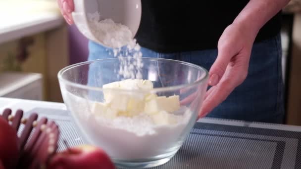 Apple pie preparation series - woman making dough pouring flour to glass bowl with butter — Wideo stockowe