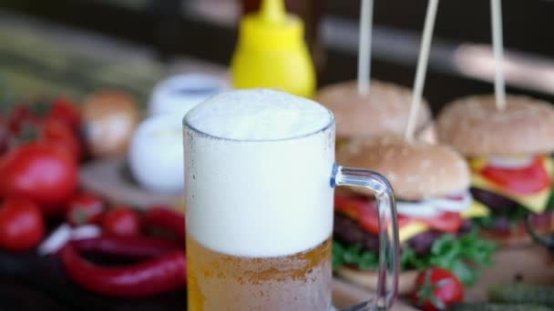 Beer glass mug with Cheeseburgers served with french fries on background — Stockvideo