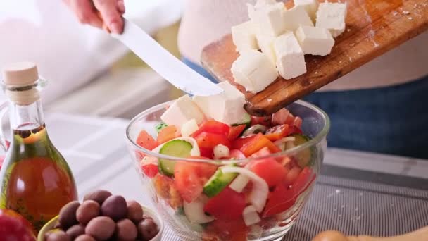 Koncepce série přípravy řeckého salátu - žena nalévá nakrájený sýr feta do misky — Stock video