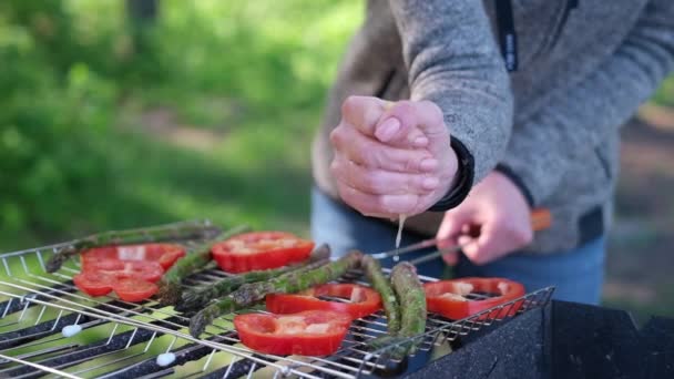 Making grilled vegetables - adding lomon juice to Asparagus and red pepper on a charcoal grill — 图库视频影像
