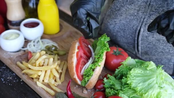 Making Hotdog - Woman adding salad to bun — Stockvideo