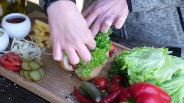 Dělat hotdog - Žena přidání salát do housky — Stock video