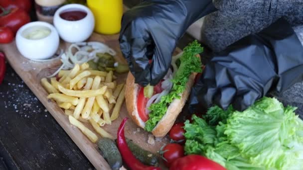 Hacer Hotdog - Mujer añadiendo pepinillos en rodajas para bollo — Vídeos de Stock