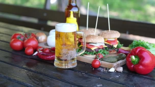 Cheeseburger serviert mit Pommes auf einem Brett im Freien — Stockvideo