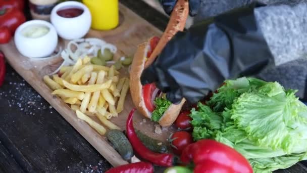 Making Hotdog - Woman adding grilled sausage to bun — Stock Video