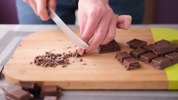 Vrouw hakken Black Dark Chocolate op houten snijplank — Stockvideo
