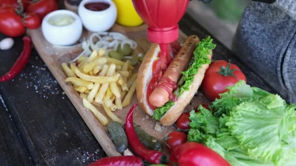 Making Hotdog - Kvinna hälla ketchup tomatsås på grillad korv — Stockvideo