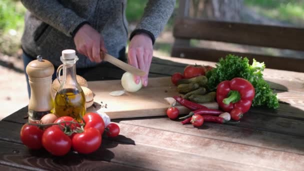 Frau schneidet Zwiebel für Gemüsesalat im Freien — Stockvideo