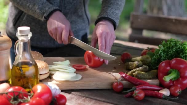 Frau schneidet Tomaten für Gemüsesalat im Freien — Stockvideo