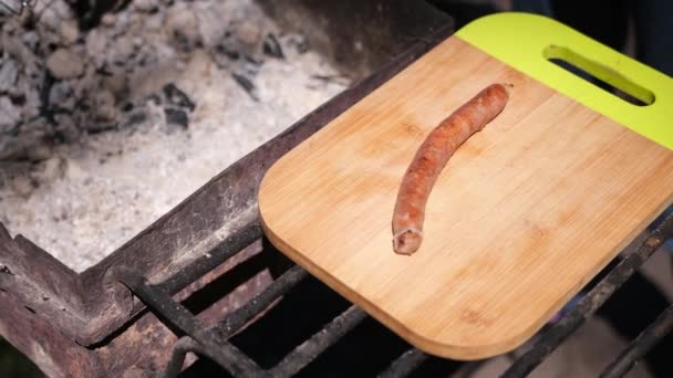 Puttung savoureuses saucisses grillées sur une planche à découper en bois — Video