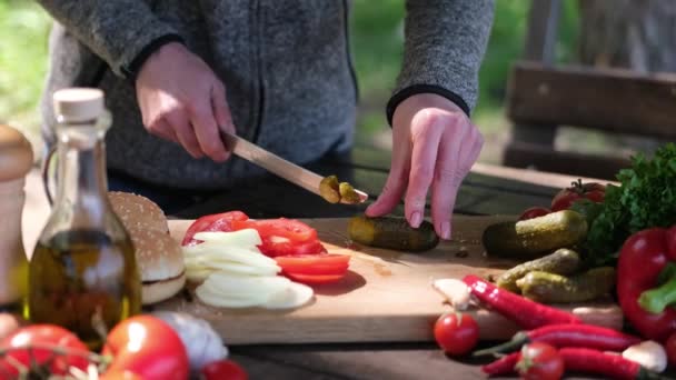 Mujer corta pepinos haciendo ensalada de verduras al aire libre — Vídeos de Stock