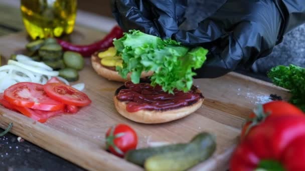 Dokonywanie Burger Umieszczenie Świeżej Sałaty Sałaty Pół Grillowanej Bułki Burger — Wideo stockowe