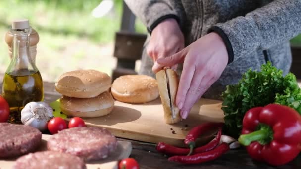 Mulher Cortada Meio Pão Hambúrguer Com Uma Faca Uma Tábua — Vídeo de Stock