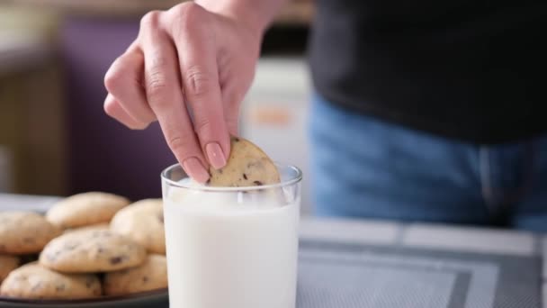 チョコレートチップクッキーをミルクのグラスに入れる女 — ストック動画