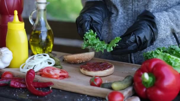 Einen Frischen Salat Auf Die Hälfte Des Gegrillten Burger Brötchens — Stockvideo