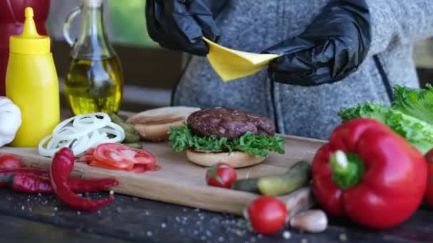 Fazer Hambúrguer Colocando Fatia Queijo Cheddar Uma Costeleta — Vídeo de Stock