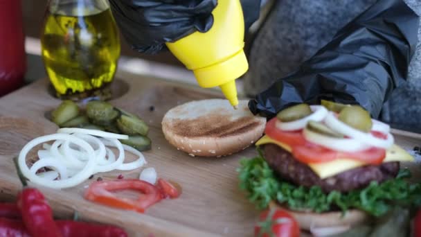 Burgerkészítés Mustárszósz Szétszórása Egy Fél Grillezett Burger Zsemlén — Stock videók