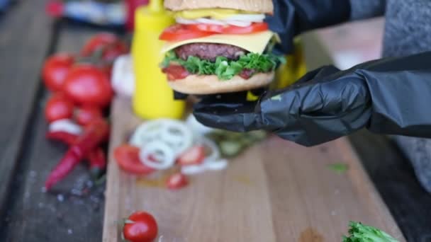 Close Shot Female Hand Holding Cheeseburger Outdoors — Stock video