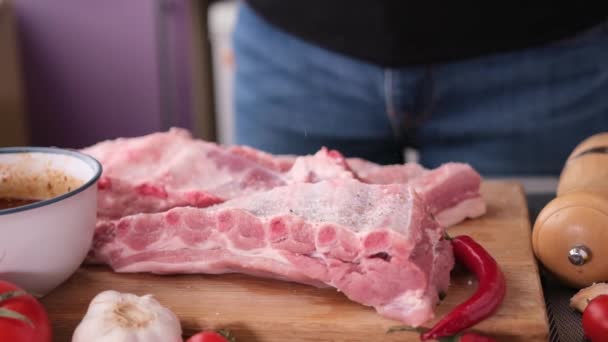 Frau Würzt Großes Stück Frische Rohe Rosa Schweinerippchen Auf Holzschneidebrett — Stockvideo