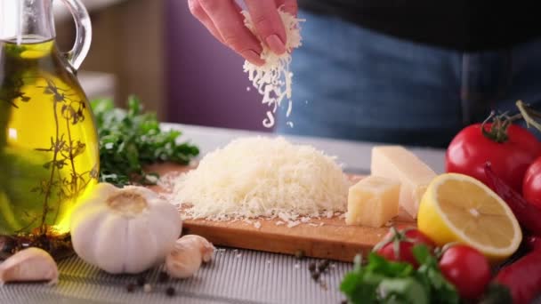 Frau Gießt Geriebenen Parmesan Häuslicher Küche Auf Holzbrett — Stockvideo