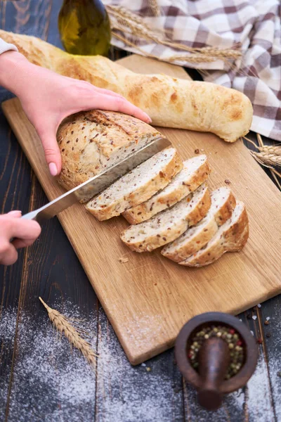 Mujer Cortando Pan Recién Horneado Mesa Cocina Madera —  Fotos de Stock