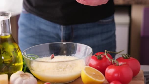 シーザーサラダソースを作る ガラスボウルにすりおろしたパルメザンチーズを追加女性 — ストック動画