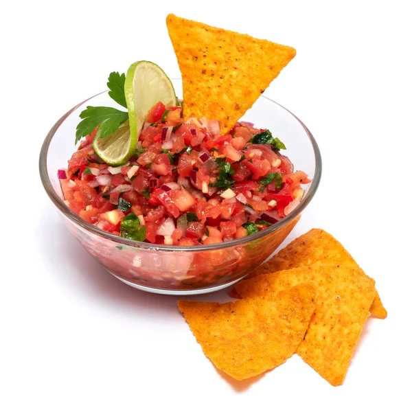 Glass bowl of tomato salsa dip with Tortilla chips isolated on white background.
